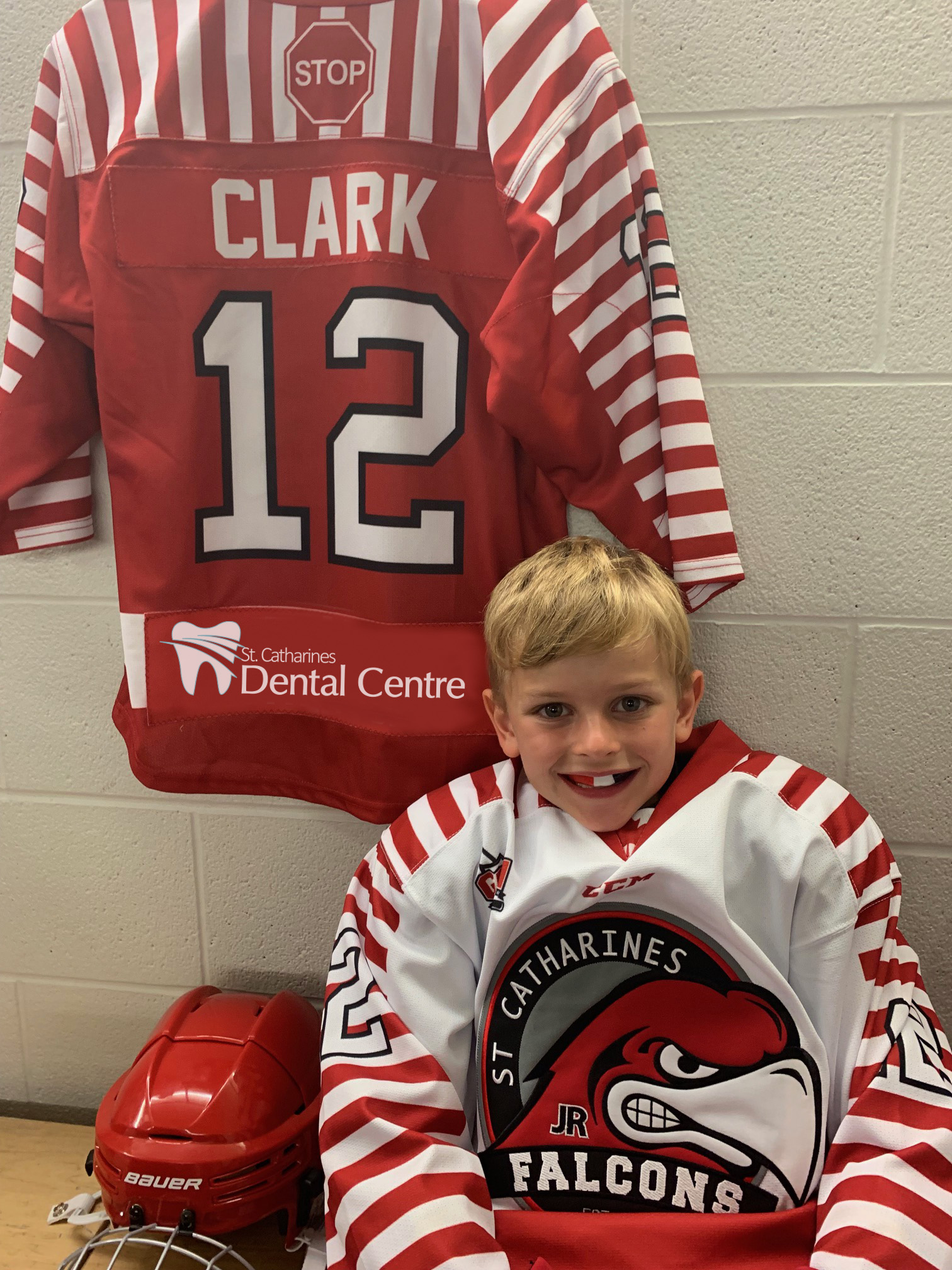 Young Boy wearing a dental guard with a hockey jersey in the background